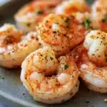 Close-up of golden-brown shrimp cooked in an air fryer with a clean background.