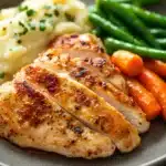Close-up of a delicious chicken breast dinner with bright and warm lighting.