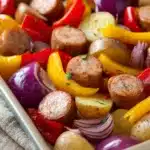 Close-up of chicken sausage with vegetables on a sheet pan, perfect for a quick lunch.