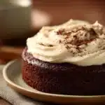 Close-up of a chocolate cake with vanilla frosting on a clean background