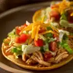 Close-up of chicken tostadas with toppings on a clean plate