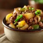 Close-up of a hearty ground beef hash with potatoes and herbs in a skillet.