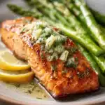 Close-up of garlic butter salmon with lemon asparagus on a white plate