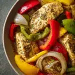 Close-up of Instant Pot chicken and peppers with a creamy sauce, garnished with herbs.