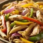 Close-up of low calorie chicken fajita pasta with creamy sauce and herbs