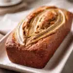 Close-up of freshly baked peanut butter banana bread with a golden crust.