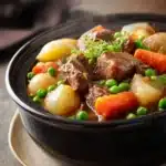 Close-up of slow cooker beef and vegetables stew with carrots and herbs in a bowl