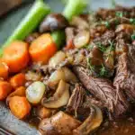Close-up of slow cooker pot roast with mushrooms in a warm, inviting setting.