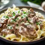 Close-up of creamy ground beef stroganoff with pasta in a bright setting