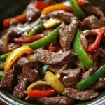 Close-up of crock pot beef pepper steak with vibrant peppers and sauce