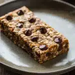 Close-up of a gluten-free bar cookie with a golden crust and chocolate chips.