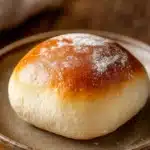 Close-up of freshly baked bread rolls with a golden crust on a clean background.