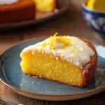 Close-up of a lemon cake with lemon yogurt, showcasing its texture and bright presentation.