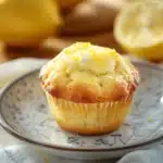 Close-up of a golden brown muffin allo yogurt e limone with a soft texture and lemon zest.
