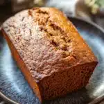 Close-up of freshly baked pumpkin bread with a golden crust on a wooden board