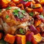 Close-up of a sheet pan dinner with roasted sweet potatoes and vegetables