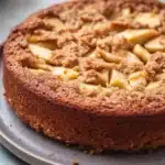 Close-up of a homemade apple cake with a golden crust, perfect for toddlers.