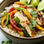 Close-up of sheet pan chicken fajitas rice bowls with colorful peppers and onions