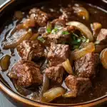 Close-up of a hearty slow cooker beef carbonnade stew with rich textures and warm lighting